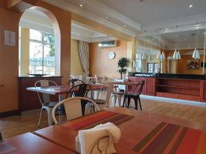 a restaurant with tables and chairs and a counter at Cube Hotel in Durban