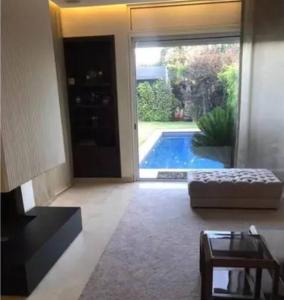 - un salon avec une porte s'ouvrant sur une piscine dans l'établissement Maison entière Securisée à Casa Green Town, à Casablanca