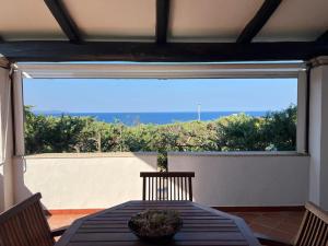 a dining room table with a view of the ocean at Villetta fronte mare a Santa Reparata in Santa Teresa Gallura