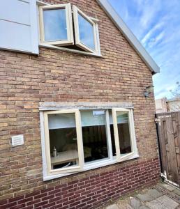 a brick house with windows on the side of it at Seaside Tiny House only 300 meters from the beach in Noordwijk