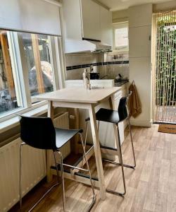 a small kitchen with a table and two chairs at Seaside Tiny House only 300 meters from the beach in Noordwijk