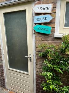 uma porta para uma casa com placas de rua em Seaside Tiny House only 300 meters from the beach em Noordwijk
