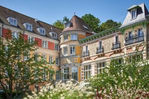 Le Grand Hôtel, The Originals Relais في Évaux-les-Bains: صف من المباني عليها شرفات