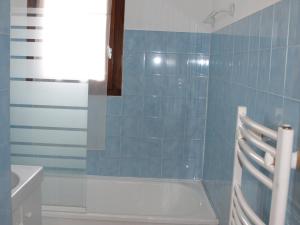 ヴァロワールにあるAppartement Valloire, 4 pièces, 6 personnes - FR-1-263-423の青いタイル張りのバスルーム(バスタブ、シンク付)