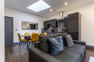 ein Wohnzimmer und eine Küche mit einem Sofa und einem Tisch in der Unterkunft Temple Court by UStay Aparthotels in Liverpool