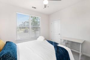 Schlafzimmer mit einem Bett, einem Schreibtisch und einem Fenster in der Unterkunft Modern Smart Apt Near Charlotte in Concord