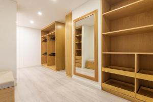 a walk in closet with wooden shelves and a mirror at The Gems by Cloud9 in Bogotá