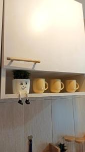 a light on a shelf in a kitchen with yellow dishes at Martha`s place Drač in Podgorica