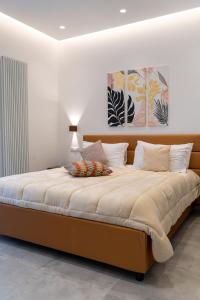 una camera da letto con un grande letto e pareti bianche di Alloggio nuovissimo al centro e rilassante a Ischia