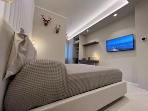 a bedroom with a bed and a tv on the wall at EMPATIA PESCARA CENTRO in Pescara
