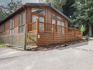 a large wooden cabin with a large deck at The Rivendale in St. Leonards