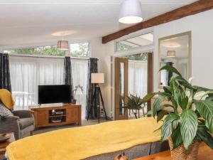 a living room with a yellow couch and a tv at The Rivendale in St. Leonards