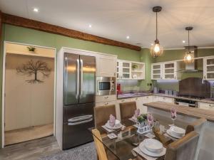 a kitchen with green walls and a stainless steel refrigerator at The Rivendale in St. Leonards