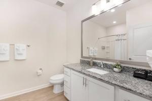 a bathroom with a sink and a toilet and a mirror at Modern Stylish Concord Condo in Concord