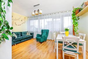 a living room with a green couch and a table at Apartamenty Maciejka in Władysławowo