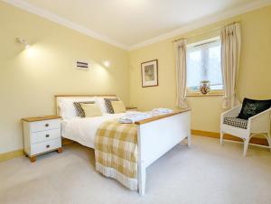 a bedroom with a bed and a chair and a window at Wisteria Way, Tangmere in Tangmere