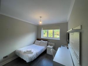 a small bedroom with a bed and a window at Ascot stunning and modern 4 bedroom town house with 156 sq ft garden office 28 in Ascot