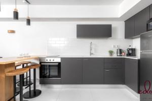 uma cozinha com electrodomésticos a preto e branco e um balcão em דירה משפחתית מרווחת 50 מטר מהים - By Edom em Eilat