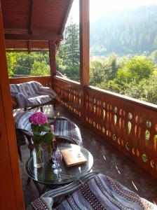 a balcony with a table with a vase of flowers at Світанкове Сяйво in Yaremche