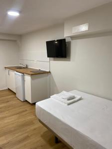 a small room with a bed and a kitchen at Hostal Mindanao in Salamanca