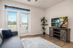 sala de estar con sofá y TV de pantalla plana en Cozy Modern Condo Near Charlotte, en Concord