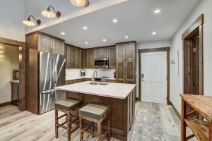 a kitchen with wooden cabinets and a stainless steel refrigerator at Fully Renovated 2 Bedroom in Arrowhead Village! condo in Edwards