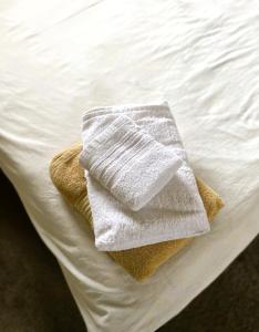 - une serviette blanche assise au-dessus du lit dans l'établissement Spanish Style 3-bedroom Home with Hot Tub, à Indianapolis