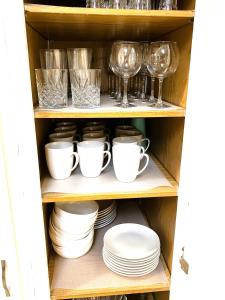 a cupboard with dishes and glasses and plates at Spanish Style 3-bedroom Home with Hot Tub in Indianapolis