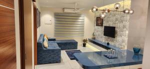 a living room with a blue couch and a tv at 1BHK LUXURY APARTMENT- Palayam in Trivandrum