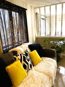 Spanish Style 3-bedroom Home with Hot Tub في انديانابوليس: أريكة عليها وسائد في غرفة المعيشة