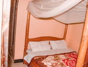 1 dormitorio con cama con dosel en CAJANUS RESORT KARATU, en Karatu