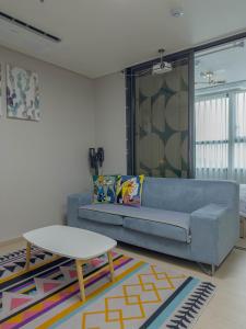 - un salon avec un canapé bleu et une table dans l'établissement KK Stay Ocean view with Netflix, à Donghae