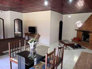 a living room with a glass table and a fireplace at Casa de campo com piscina a 2 min de cunha in Cunha