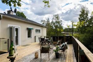 a patio with chairs and a table on a deck at Room in a spacious villa in Stocksund