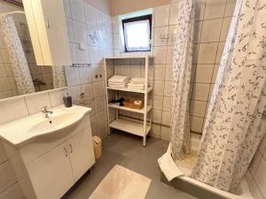 a bathroom with a sink and a shower curtain at Apartment & Room Monika in Rakovica