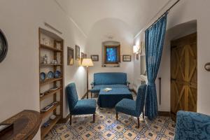 a living room with blue chairs and a table at Relais Villa Giusso in Vico Equense