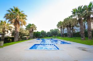 a swimming pool with palm trees in a park at Presidential suite Villamartin Plaza First line Golf Quiet and confortable in Alicante