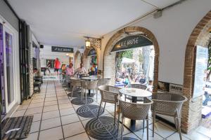 un restaurante con mesas y sillas y gente caminando por ahí en Presidential suite Villamartin Plaza First line Golf Quiet and confortable, en Alicante
