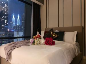 sypialnia z białym łóżkiem z kwiatami w obiekcie 1 min to Pavilion KL Heart of Bukit Bintang by GBS w Kuala Lumpur