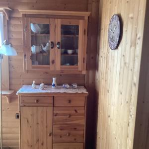 a kitchen with a wooden cabinet and a clock on a wall at Chalet Spessart in Dammbach