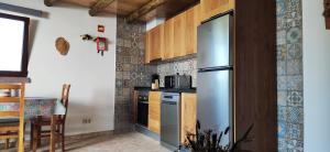 uma cozinha com um frigorífico de aço inoxidável e uma mesa em Familia Sequeira em São Bartolomeu de Messines