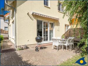 einen Grill auf einer Terrasse mit einem Tisch und Stühlen in der Unterkunft Kirchstr 4a in Bansin
