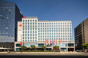 a large white building with flags in front of it at Austria Trend Hotel Ljubljana in Ljubljana