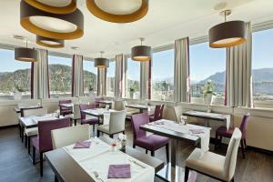 a restaurant with tables and chairs and windows at Austria Trend Hotel Europa Salzburg in Salzburg