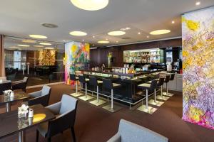 a restaurant with a bar and tables and chairs at Austria Trend Hotel Europa Wien in Vienna