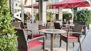 a group of tables and chairs with umbrellas on a sidewalk at Austria Trend Hotel Europa Wien in Vienna