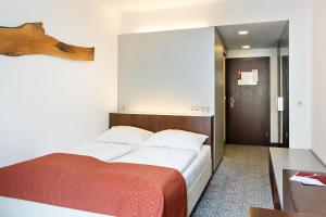 a bedroom with a bed with a red blanket at Austria Trend Hotel Europa Wien in Vienna