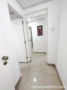 pasillo con 2 puertas blancas y suelo de baldosa en Departamento Miraflores, en Lima