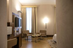una camera d'albergo con letto, tavolo e sedie di Risorgimento Resort a Lecce