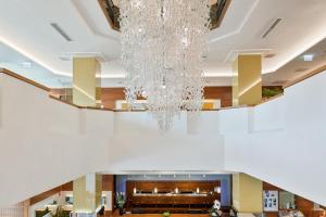 a large chandelier hangs from the ceiling of a lobby at Austria Trend Hotel Europa Graz Hauptbahnhof in Graz